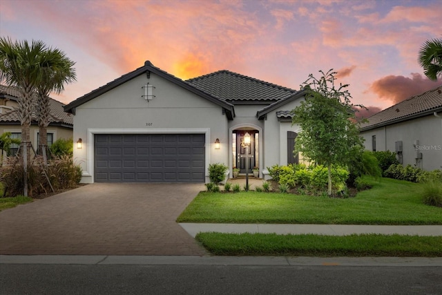 mediterranean / spanish-style house with a yard and a garage