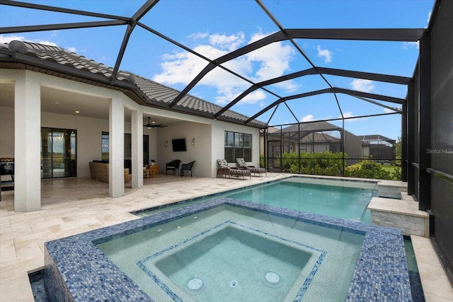 view of swimming pool featuring a lanai, an in ground hot tub, ceiling fan, and a patio