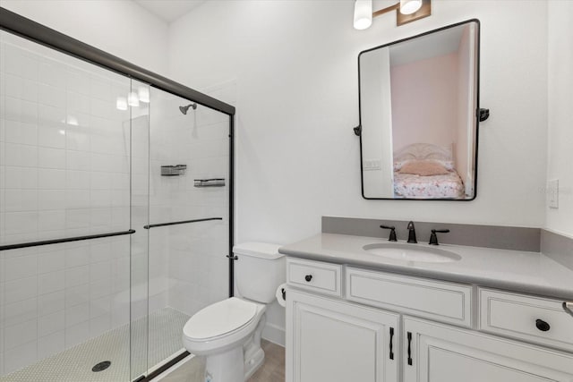 bathroom featuring vanity, toilet, and a shower with door