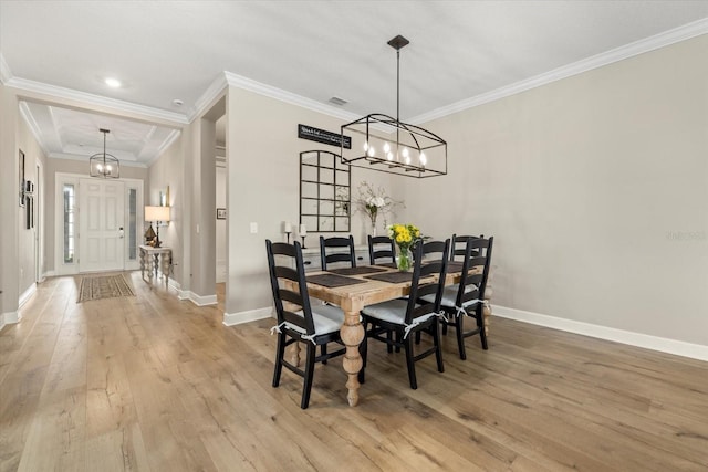 dining area with a notable chandelier, wood-type flooring, and crown molding