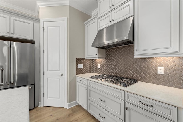 kitchen featuring decorative backsplash, light wood-type flooring, ornamental molding, stainless steel appliances, and white cabinets