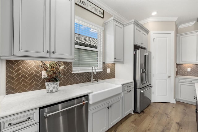 kitchen with decorative backsplash, appliances with stainless steel finishes, ornamental molding, and sink