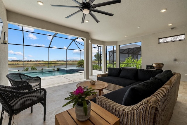 view of patio / terrace with a lanai, an outdoor living space, a water view, and ceiling fan