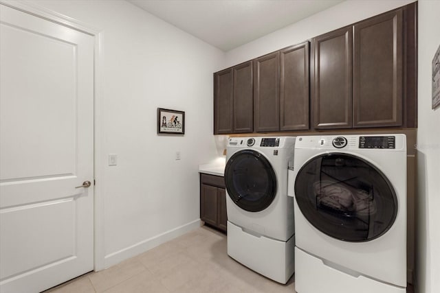 laundry room with washer and dryer and cabinets