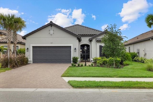 mediterranean / spanish-style home featuring a garage and a front yard