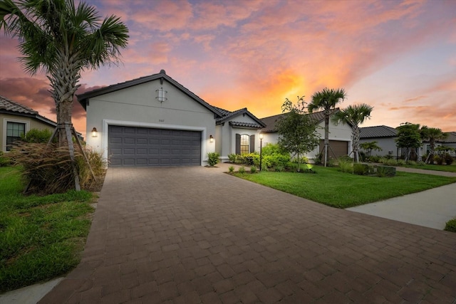 view of front of home with a garage and a lawn