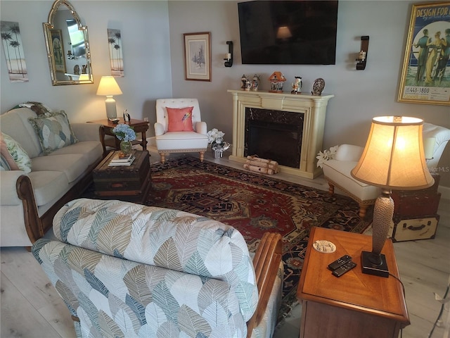 living room featuring a high end fireplace and hardwood / wood-style flooring