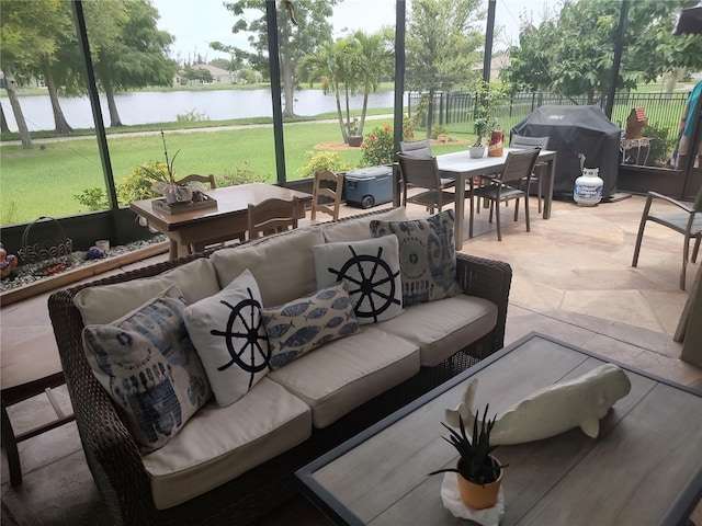 exterior space featuring a water view, an outdoor living space, and a grill