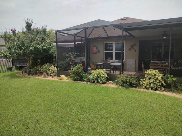 view of yard with a lanai, ceiling fan, and a patio area