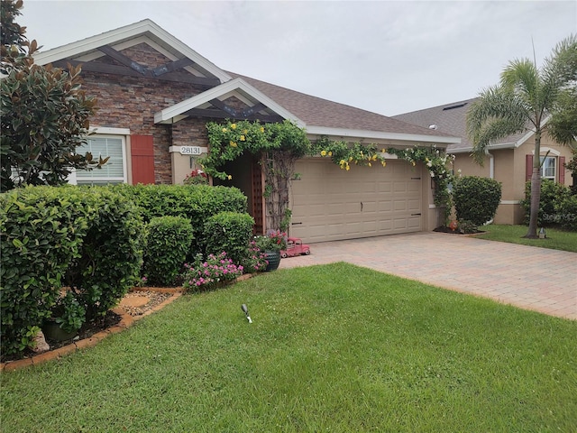 single story home featuring a garage and a front yard