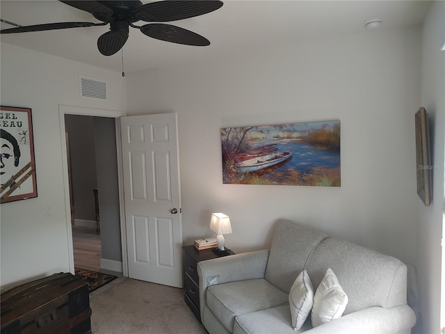 sitting room with ceiling fan and carpet