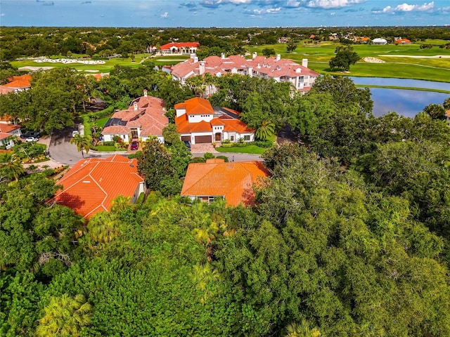 drone / aerial view with a residential view, view of golf course, and a water view