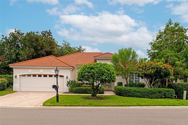 mediterranean / spanish-style home featuring a front yard and a garage