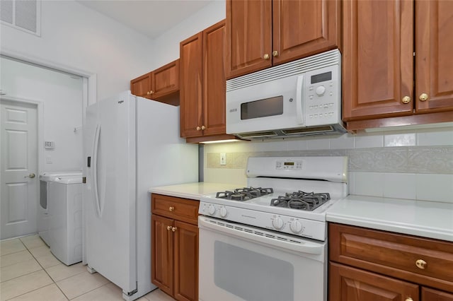 kitchen with visible vents, washer / clothes dryer, white appliances, light countertops, and decorative backsplash