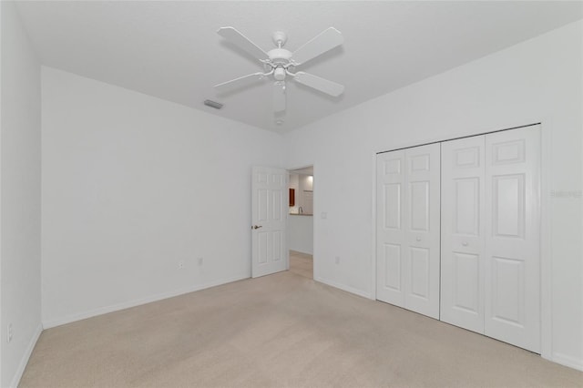 unfurnished bedroom with visible vents, a closet, carpet floors, baseboards, and ceiling fan