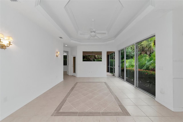 spare room featuring light tile patterned floors, visible vents, baseboards, ceiling fan, and a raised ceiling