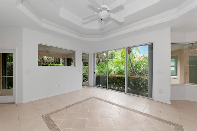 unfurnished sunroom featuring a tray ceiling and ceiling fan