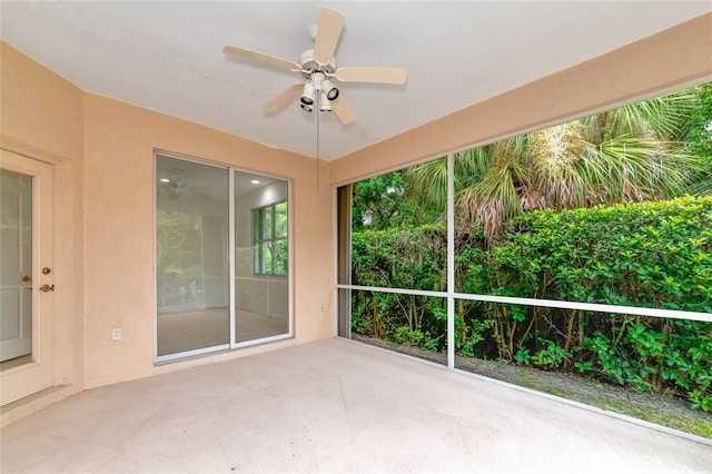 unfurnished sunroom featuring a ceiling fan