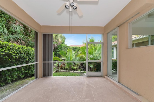 unfurnished sunroom featuring a ceiling fan