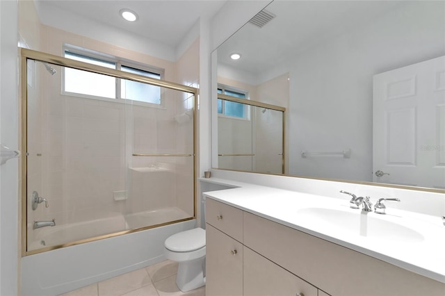 bathroom featuring visible vents, toilet, combined bath / shower with glass door, tile patterned flooring, and vanity