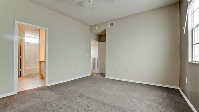 unfurnished bedroom featuring connected bathroom, ceiling fan, and light colored carpet