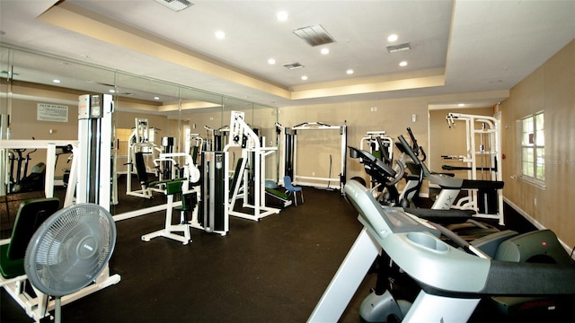 exercise room featuring a tray ceiling, visible vents, and recessed lighting