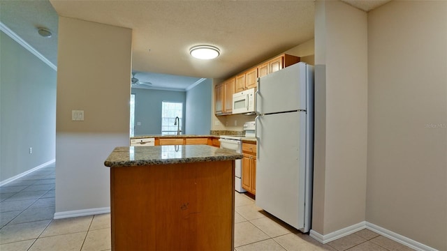 kitchen featuring light tile patterned floors, white appliances, a sink, ornamental molding, and a center island