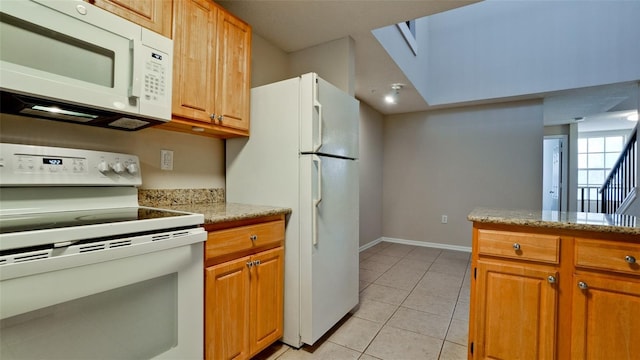 kitchen featuring white appliances, light tile patterned floors, baseboards, brown cabinetry, and light stone counters