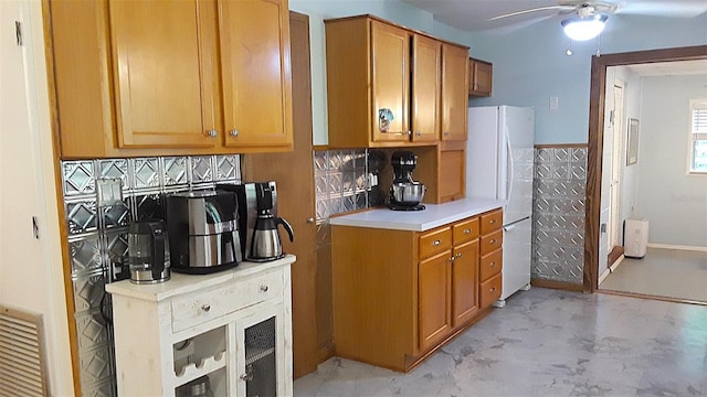 kitchen featuring ceiling fan, white fridge, and tasteful backsplash