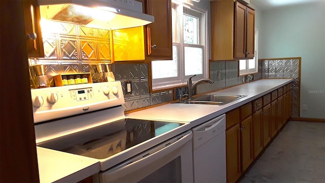 kitchen with stainless steel electric range oven, brown cabinetry, a sink, dishwasher, and exhaust hood