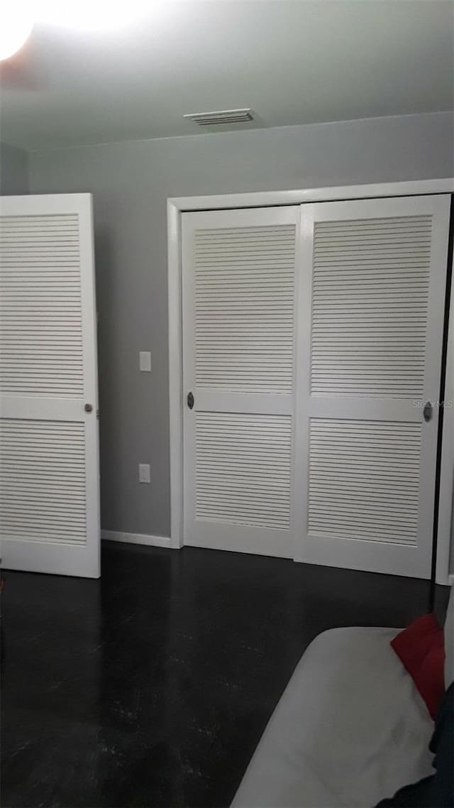 bedroom with a closet, visible vents, and baseboards