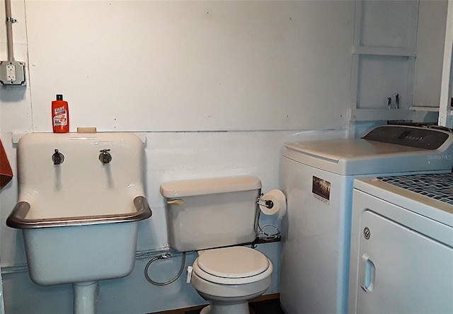 bathroom with toilet and washer and dryer