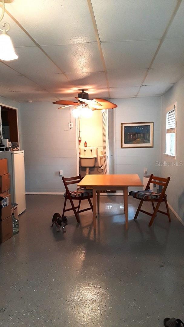 dining space featuring ceiling fan and a paneled ceiling