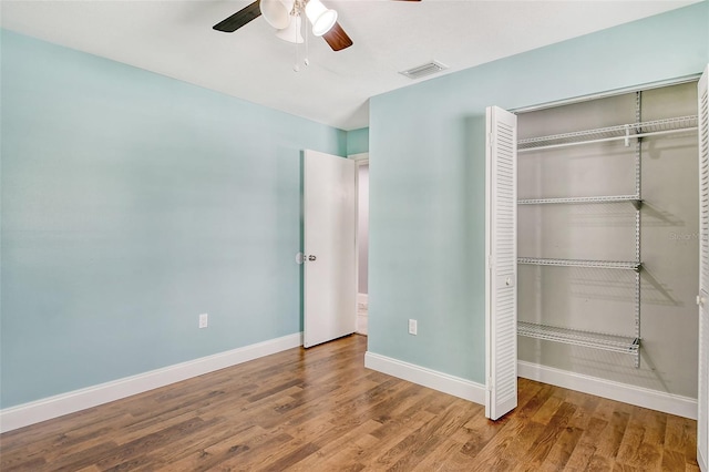 unfurnished bedroom featuring wood-type flooring, a closet, and ceiling fan