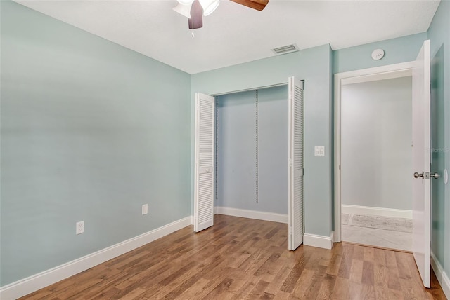 unfurnished bedroom with hardwood / wood-style floors, a closet, and ceiling fan