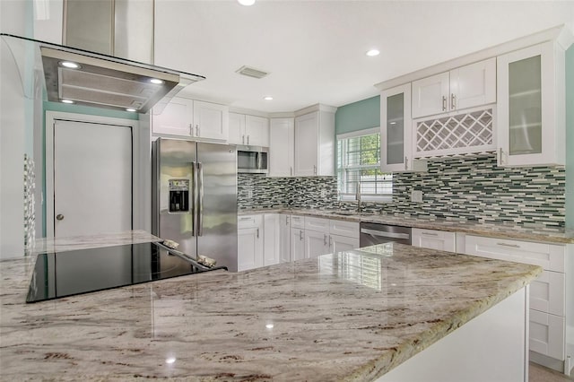 kitchen with light stone counters, white cabinetry, decorative backsplash, and appliances with stainless steel finishes