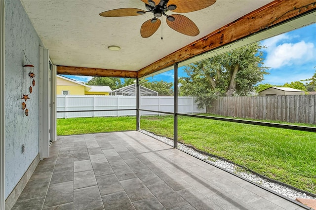 unfurnished sunroom with ceiling fan