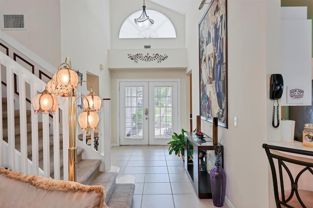 tiled entrance foyer with high vaulted ceiling and french doors