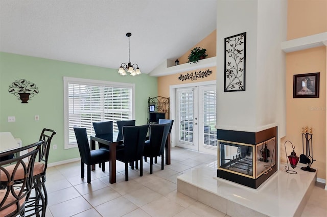 dining room featuring a wealth of natural light, light tile patterned floors, french doors, and a chandelier