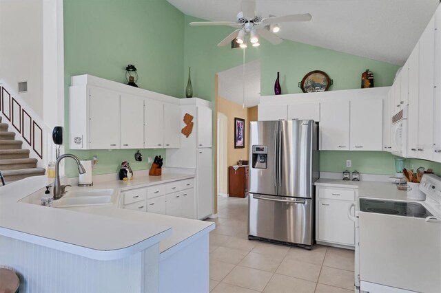 kitchen with range, sink, stainless steel fridge with ice dispenser, light tile patterned flooring, and high vaulted ceiling