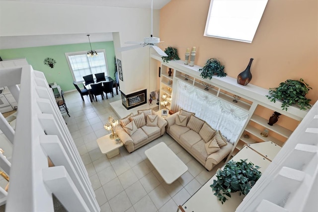 living room with tile patterned floors, high vaulted ceiling, and ceiling fan