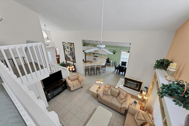 living room with tile patterned floors, ceiling fan, and high vaulted ceiling