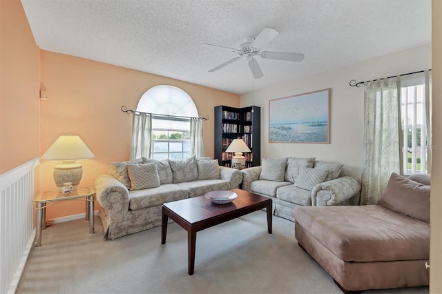 living room with carpet floors, a textured ceiling, and ceiling fan