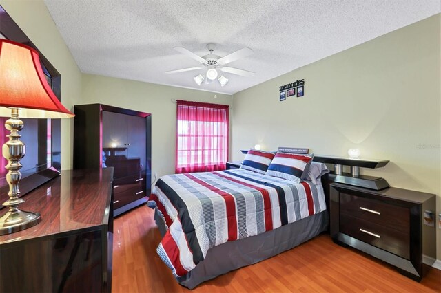 bedroom with wood-type flooring, a textured ceiling, and ceiling fan