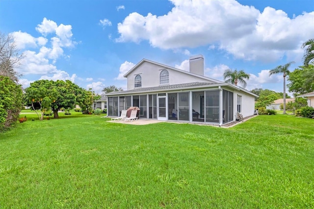 rear view of property featuring a sunroom and a lawn