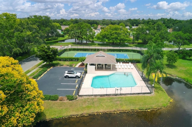 view of swimming pool with a water view and a lawn