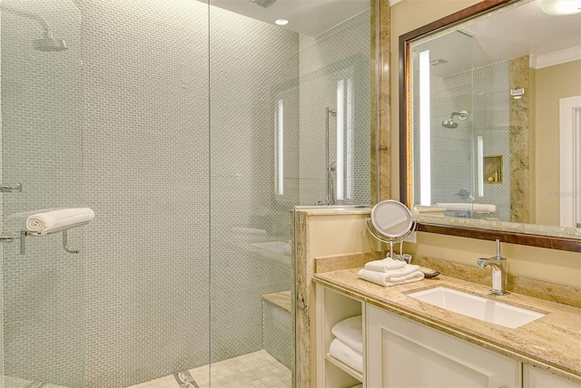 bathroom with a shower with shower door and vanity