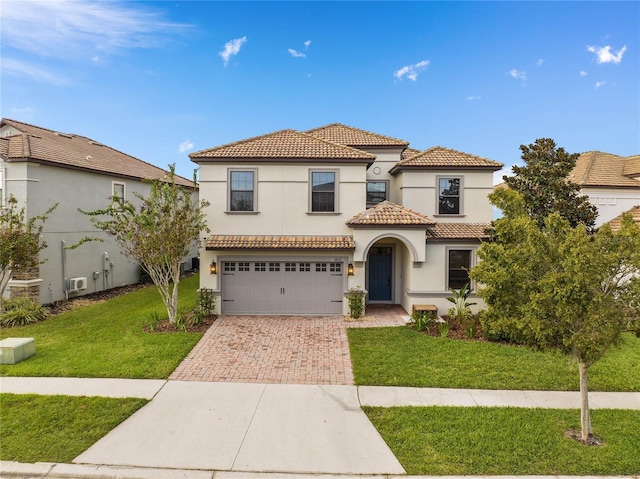 mediterranean / spanish-style home with a garage and a front lawn