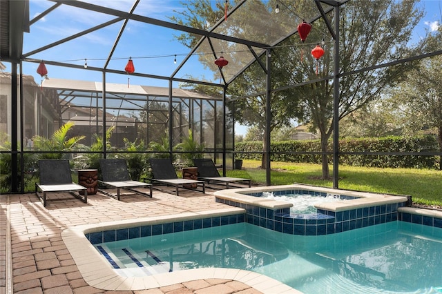 view of swimming pool featuring a patio area, an in ground hot tub, and a lanai