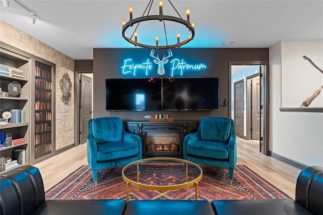 living room featuring light hardwood / wood-style flooring, rail lighting, and a chandelier